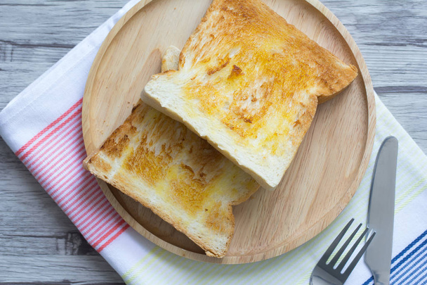 Toast with butter on a wooden plate - Φωτογραφία, εικόνα