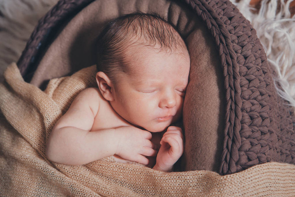 newborn baby wrapped in a blanket sleeping in a basket - Фото, изображение