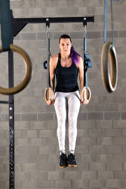 Young woman doing muscle up exercises on rings - Photo, Image