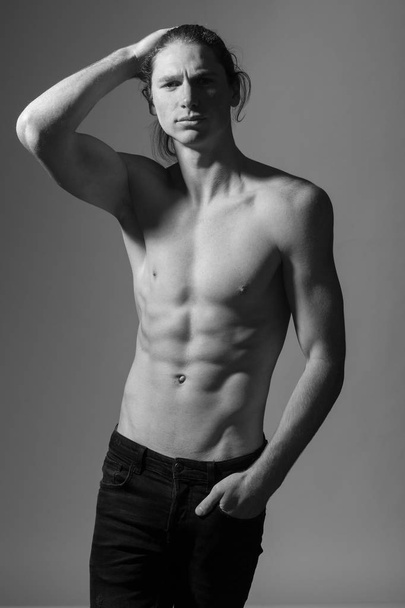 Black and white photo of a topless man. Gray background - Photo, Image