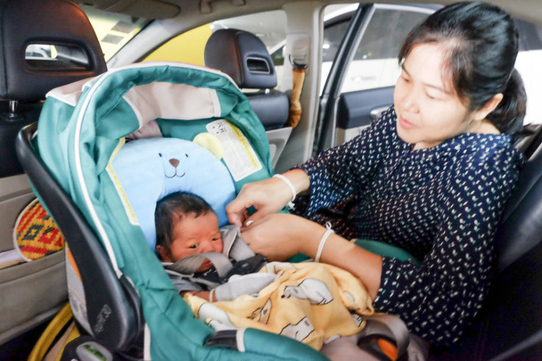 Mãe com menino infantil dentro de assento de carro savfty
 - Foto, Imagem
