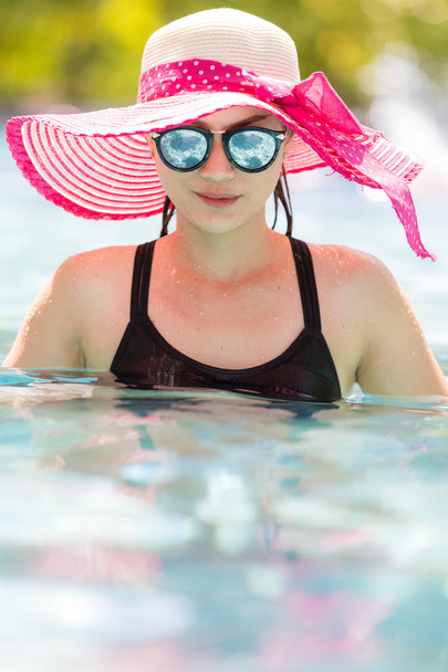 Woman wear sunglasses in pool. - Фото, зображення