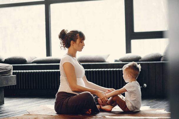 Mère avec petit fils faisant du yoga à la maison
 - Photo, image