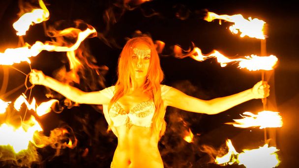 Feuerwehrfrau tanzt mit brennenden Ventilatoren - Foto, Bild