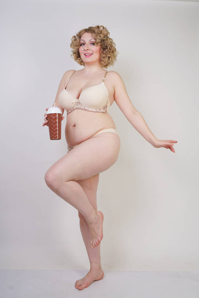 hübsche kaukasische mollige Frau mit Plus-Size-Körper und blasser Haut trägt Unterwäsche Mode Dessous auf weißem Studiohintergrund - Foto, Bild