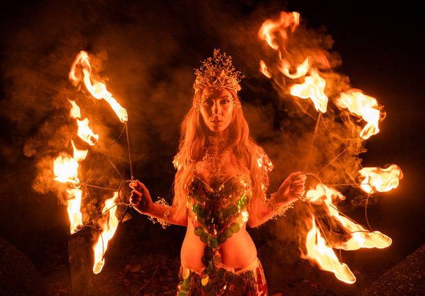 燃える楽しみでポーズをとる火の女性 - 写真・画像