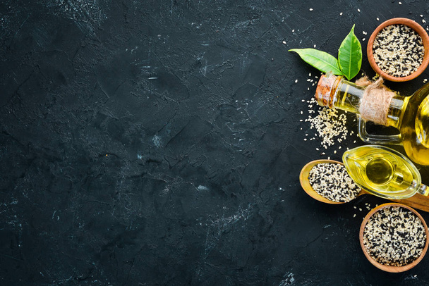 Seeds of sesame and sesame oil. On the old background. Top view. Free copy space. - Fotografie, Obrázek