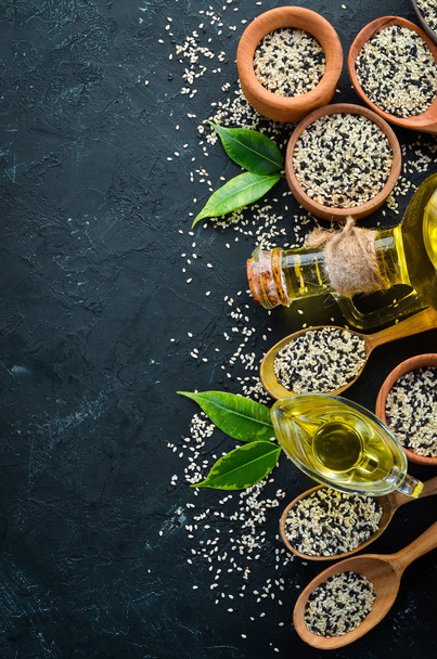 Seeds of sesame and sesame oil. On the old background. Top view. Free copy space. - Foto, afbeelding