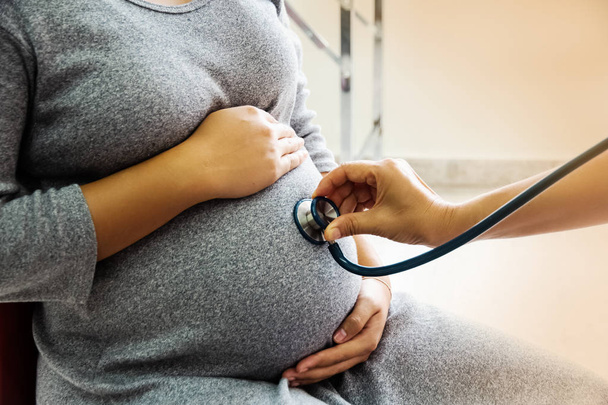 The pregnant woman was examining,The doctor hand using stethoscope put on belly,for health check,Health care and Medical concept - Foto, afbeelding