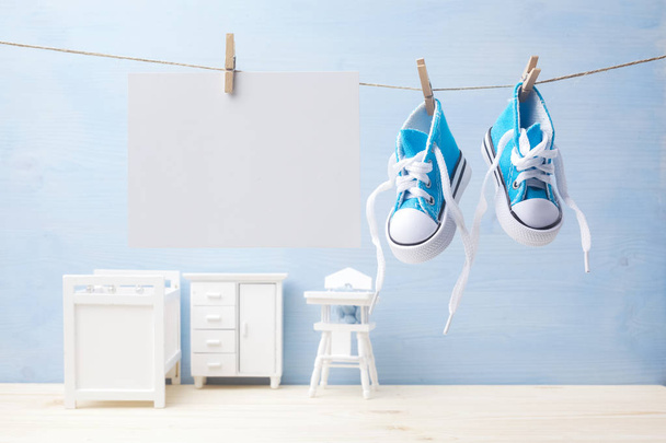 Cute little baby shoes hanghang on rope in baby room background - Foto, Imagen
