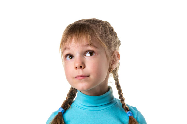 Retrato de uma jovem menina ingênua sonhadora com olhos grandes, olhando para cima. Menina com duas tranças, isolado no fundo da paisagem branca
 - Foto, Imagem
