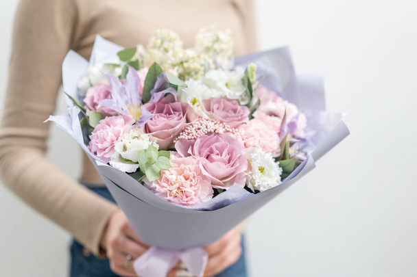 schöner Strauß gemischter Blumen in Frauenhand. die Arbeit des Blumenhändlers in einem Blumenladen. zarte Pastellfarbe. frische Schnittblume. rosa und lila Farbe - Foto, Bild