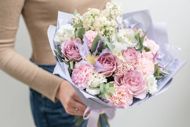 Beautiful bouquet of mixed flowers in woman hand. the work of the florist at a flower shop. Delicate Pastel color. Fresh cut flower. Pink and lilac color - Valokuva, kuva