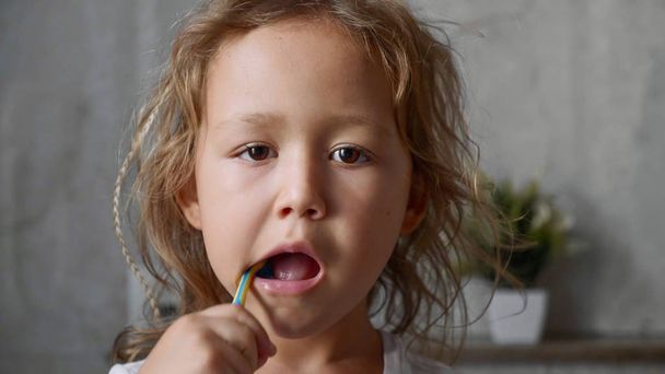 Портрет маленької дівчинки інтенсивно чистить зуби у ванній
 - Фото, зображення