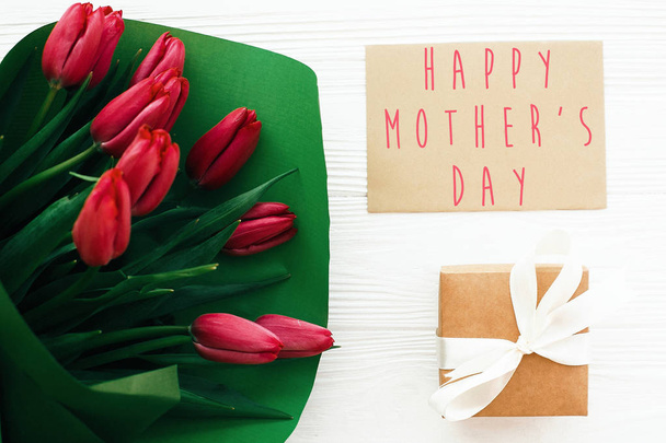 Happy Mother's Day text and beautiful red tulips with gift box o - Фото, изображение