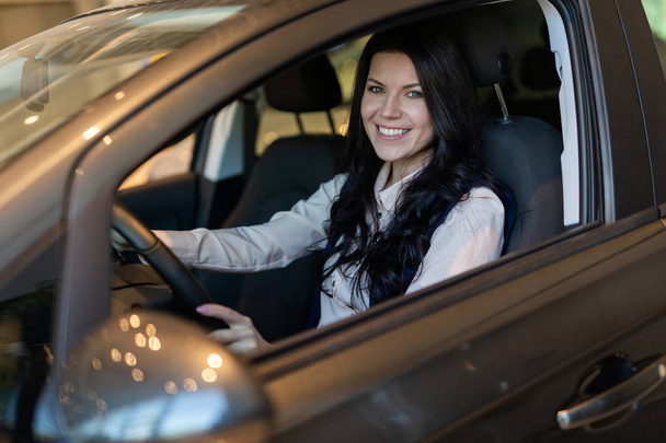 Szczęśliwa kobieta klient zakup nowego samochodu w centrum dealcenter. - Zdjęcie, obraz