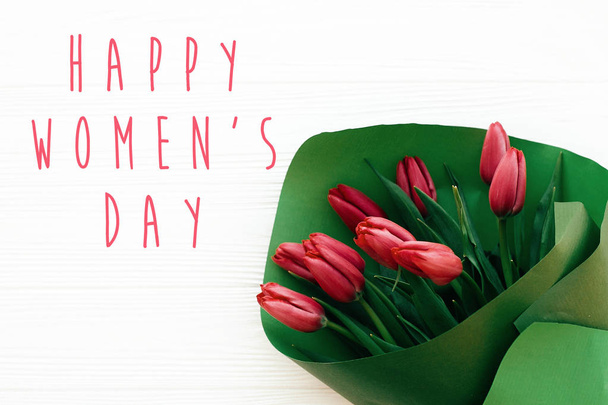 Texto del Día de la Mujer Feliz y hermosos tulipanes rojos sobre madera blanca
  - Foto, Imagen