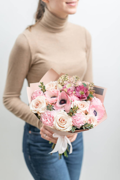 schöner Strauß gemischter Blumen in Frauenhand. die Arbeit des Blumenhändlers in einem Blumenladen. zarte Pastellfarbe. frische Schnittblume. rosa und weiße Farbe - Foto, Bild