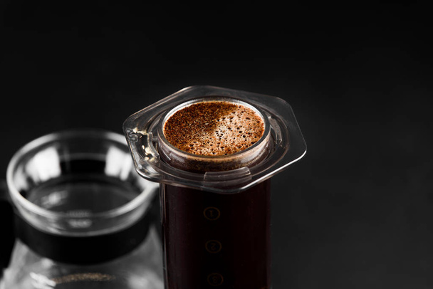AeroPress on black background .The AeroPress is a device for brewing coffee. Coffee brewing - Foto, Imagen