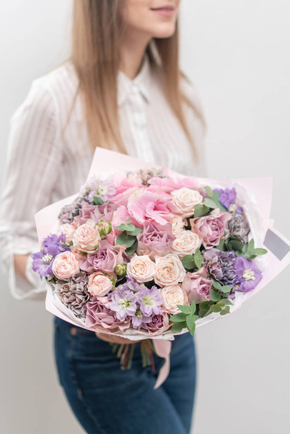 Bellissimo bouquet di fiori misti in mano donna. il lavoro del fioraio in un negozio di fiori. Colore pastello delicato. Fiore reciso fresco. Colore rosa e lilla
 - Foto, immagini