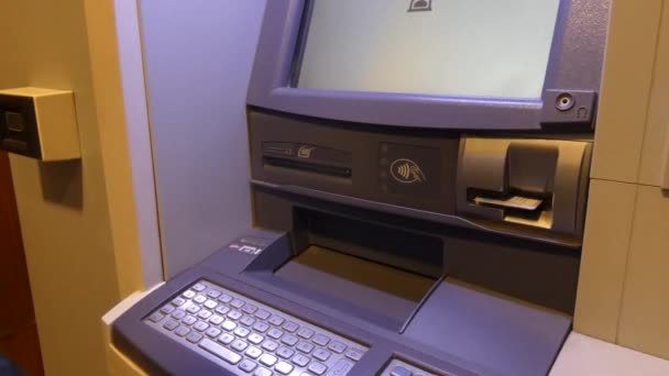 Een persoon wacht op een kaart van de ATM - Video