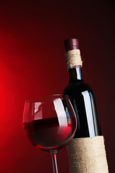 келих вина з пляшкою на яскраво-червоному тлі
 - Фото, зображення