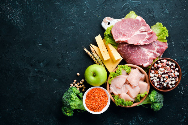 Assortment of healthy protein source and body building foods. Meat, chicken fillet, broccoli, beans, cheese, eggs, wheat. On a stone background. - Foto, Bild