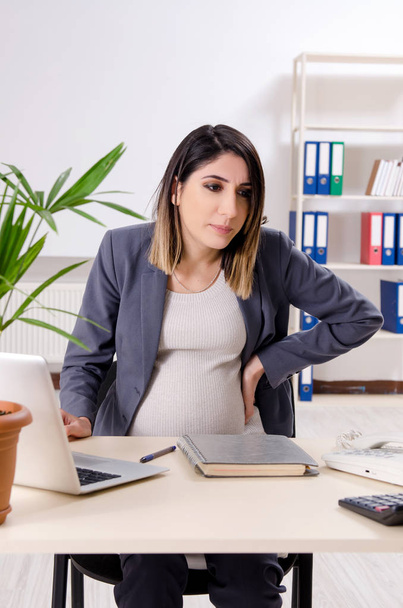 Jovem funcionária grávida trabalhando no escritório  - Foto, Imagem