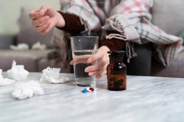 hand holding water glass with pills on table - Foto, afbeelding