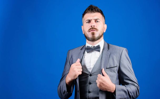 Man adjust suit with bow tie. Well groomed man with beard in formal suit jacket. Male fashion and aesthetic. Businessman formal outfit. Classic style aesthetic. Perfect suit fit him. Menswear shop - Foto, Bild