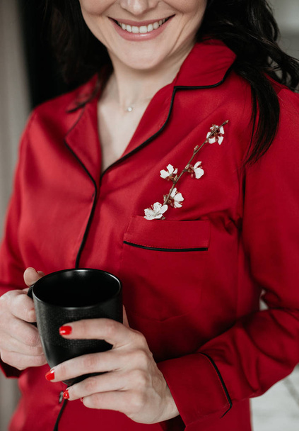 morning woman red pajamas smile flower cup - Foto, afbeelding