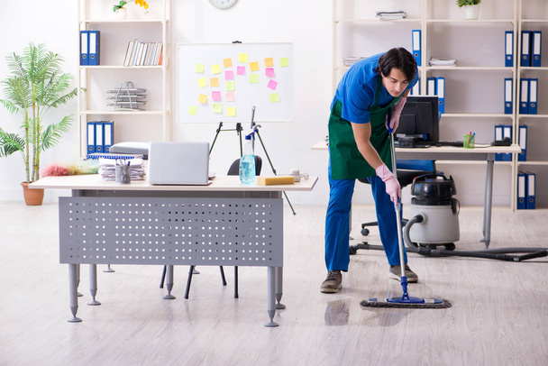 Άνδρας όμορφος επαγγελματίας καθαριστής εργάζεται στο γραφείο  - Φωτογραφία, εικόνα