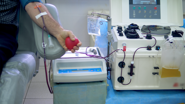 Una persona dona sangre que es transportada a través de la máquina
 - Metraje, vídeo