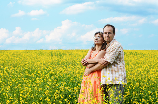 Happy man and woman in yellow meadow - Foto, afbeelding