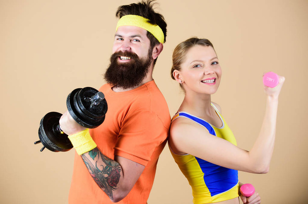 Healthy lifestyle concept. Man and woman exercising with dumbbells. Fitness exercises with dumbbells. Workout with dumbbells. Girl and guy hold dumbbells. Fitness sport exercises. Sporty family - Foto, Bild