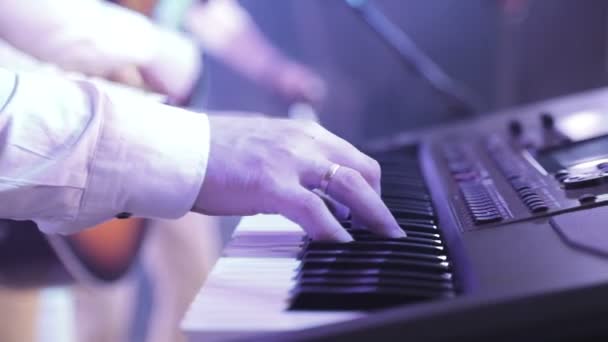 dedos do músico que toca no sintetizador eletrônico durante o concerto
 - Filmagem, Vídeo