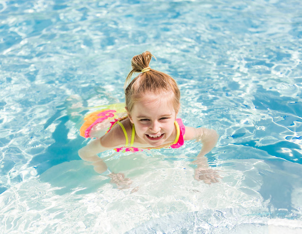 усміхнена дівчина пливе до басейну
 - Фото, зображення