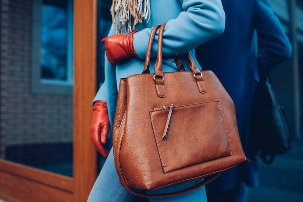 Краса і мода. Стильна модна жінка в пальто і рукавичках, що тримає коричневу сумку
 - Фото, зображення