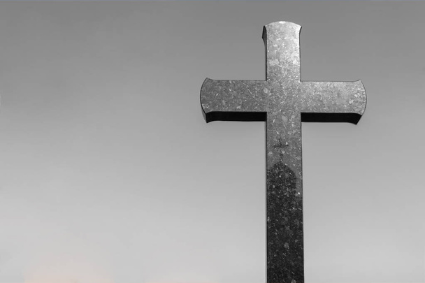 πέτρινο σταυρό σε ένα νεκροταφείο με χώρο αντιγραφής για κείμενο. σταυρό σε γκρίζο φόντο - Φωτογραφία, εικόνα