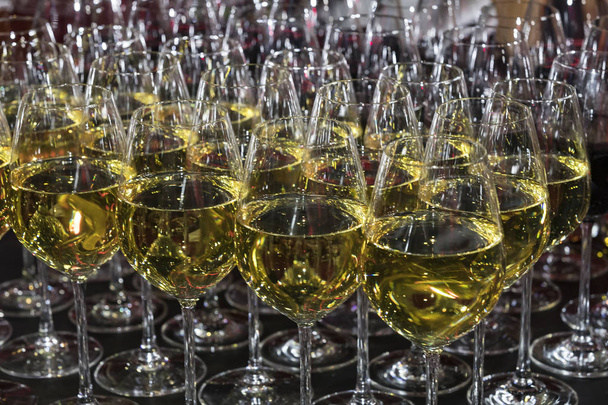 Fileiras de copos cheios de vinho em um banquete romântico em uma boate close-up shot
. - Foto, Imagem