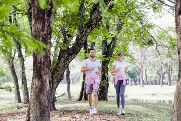 Beautiful couple jogging in park living, Concept healthy in natur
 - Фото, изображение