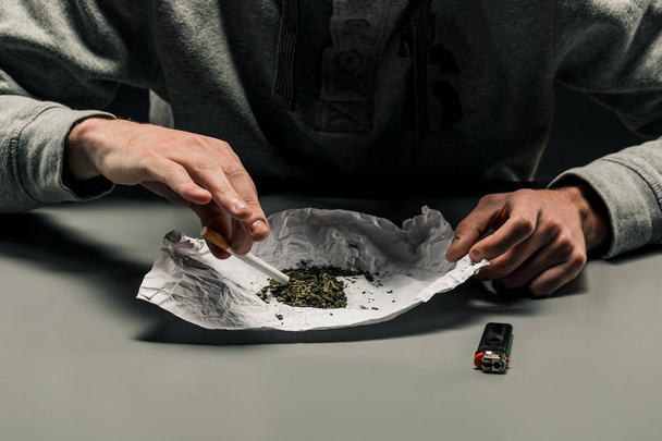 Egy drogfüggő teszi a marihuána cigarettát. D fogalma - Fotó, kép