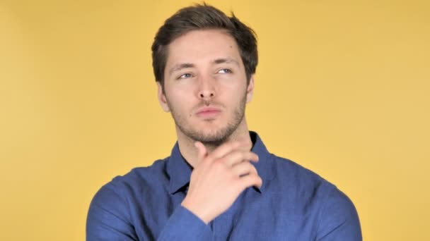 Nachdenklicher junger Mann hat neue Idee auf gelbem Hintergrund - Filmmaterial, Video