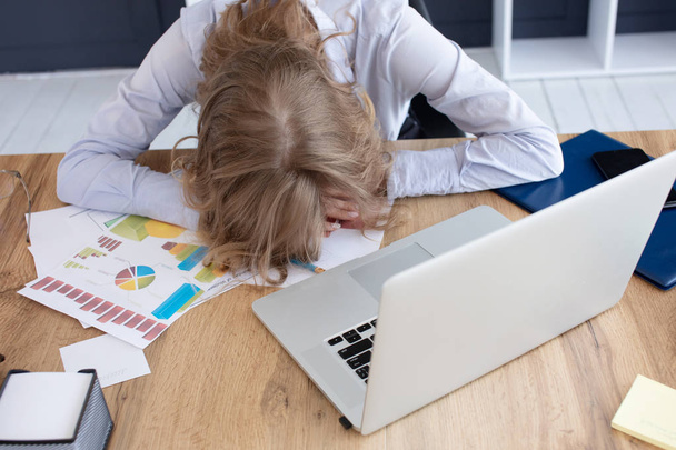 junge frustrierte Frau legte ihren Kopf auf den Tisch und saß an einem weißen Schreibtisch mit modernem PC-Laptop. Leistung Business-Karriere-Konzept - Foto, Bild