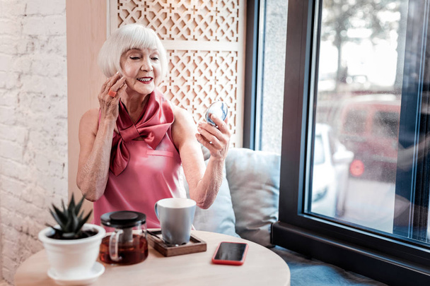 Beautiful bright old woman correcting her accurate hairstyle - Foto, imagen