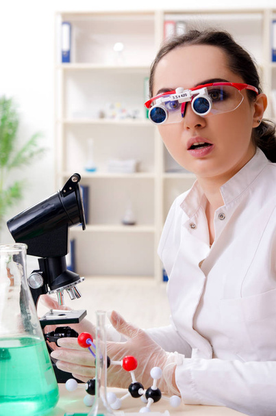 Νεαρή γυναίκα χημικός εργάζεται στο εργαστήριο  - Φωτογραφία, εικόνα