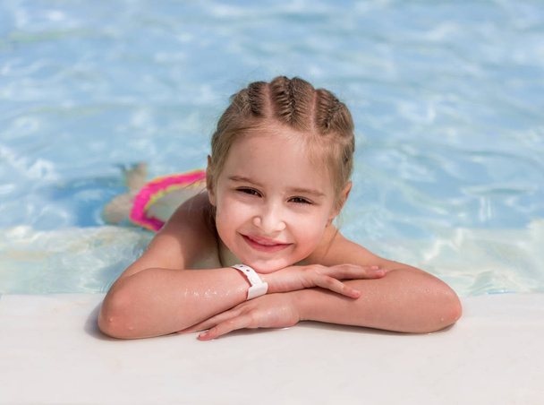 Smiling girl swim to the poolside - Photo, Image