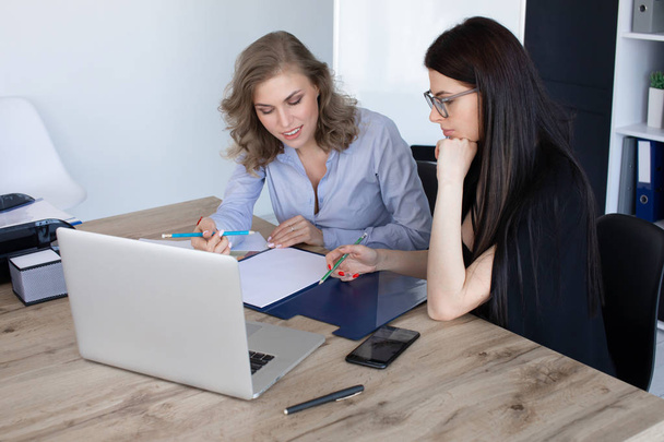 Business women at office desk working together on a laptop, teamwork concept - Φωτογραφία, εικόνα