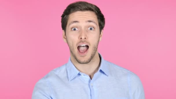 Vinger op lippen door jonge man geïsoleerd op roze achtergrond - Video
