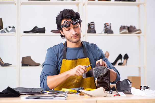 Fiatal férfi cipő műhelyben javítása  - Fotó, kép